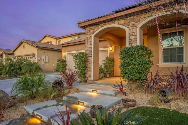 exterior entry at dusk with a garage