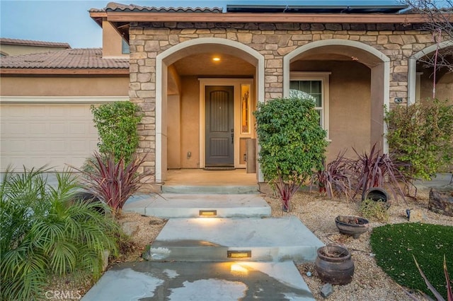 property entrance featuring a garage and solar panels