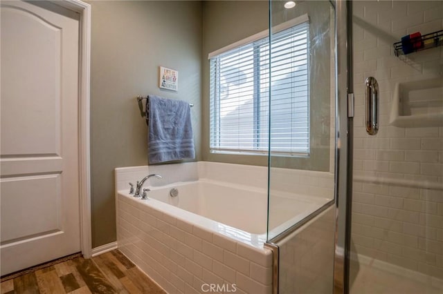 bathroom featuring hardwood / wood-style flooring and shower with separate bathtub