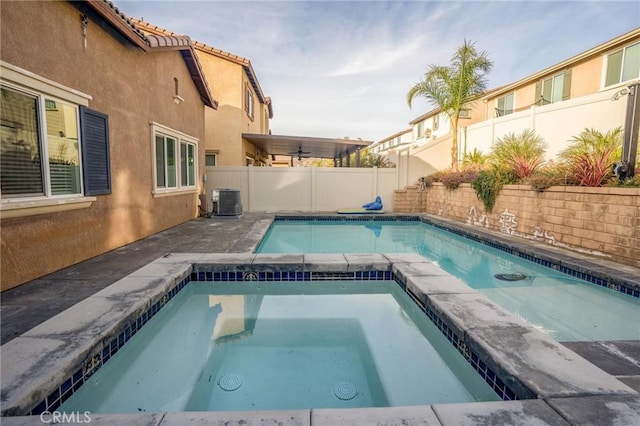 view of swimming pool with central air condition unit and an in ground hot tub