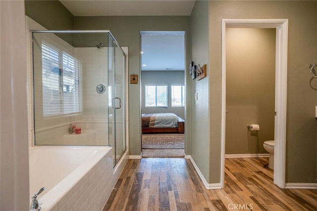 bathroom featuring toilet, wood-type flooring, and plus walk in shower