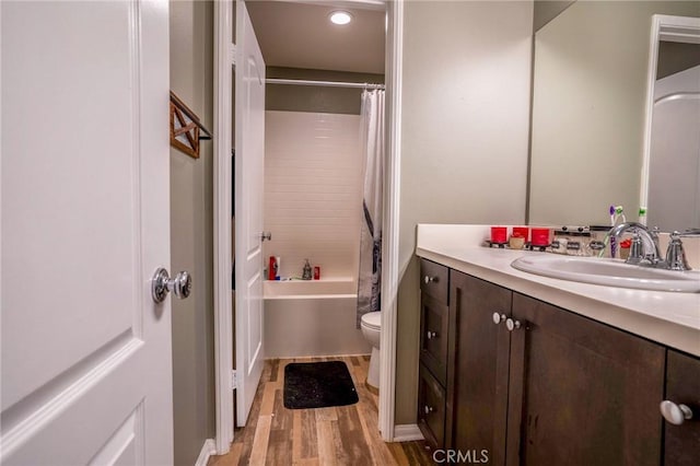 full bathroom featuring toilet, hardwood / wood-style flooring, vanity, and shower / bath combo with shower curtain