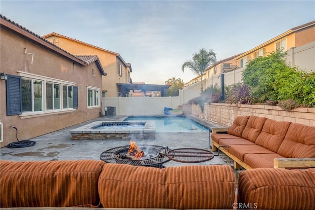 view of swimming pool with an outdoor living space with a fire pit and central AC