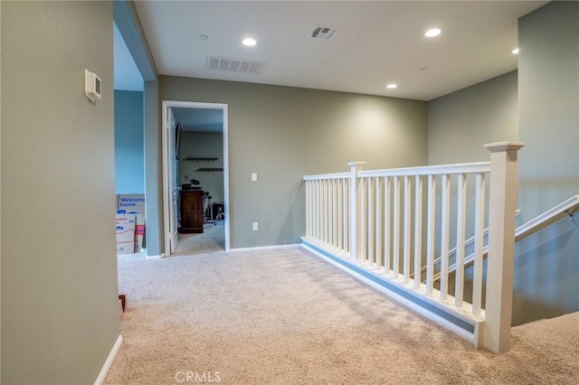 hallway with light colored carpet