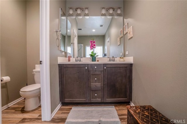 bathroom with wood-type flooring, toilet, and vanity