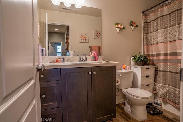 bathroom with toilet, vanity, and hardwood / wood-style flooring