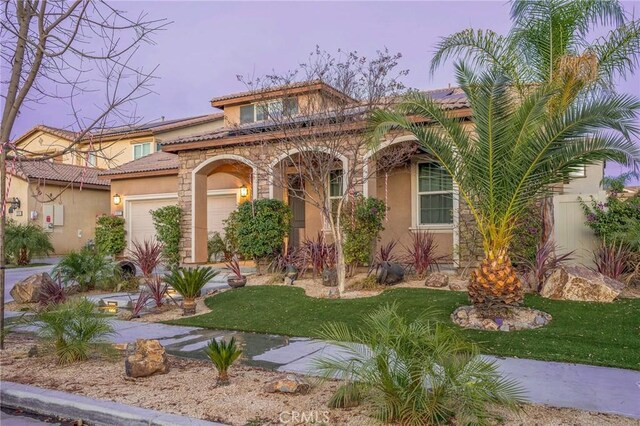 mediterranean / spanish home with a front yard and a garage