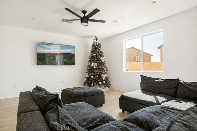 living room with light wood-type flooring and ceiling fan