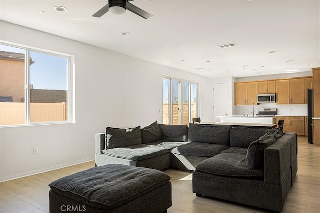 living room featuring ceiling fan and light hardwood / wood-style floors