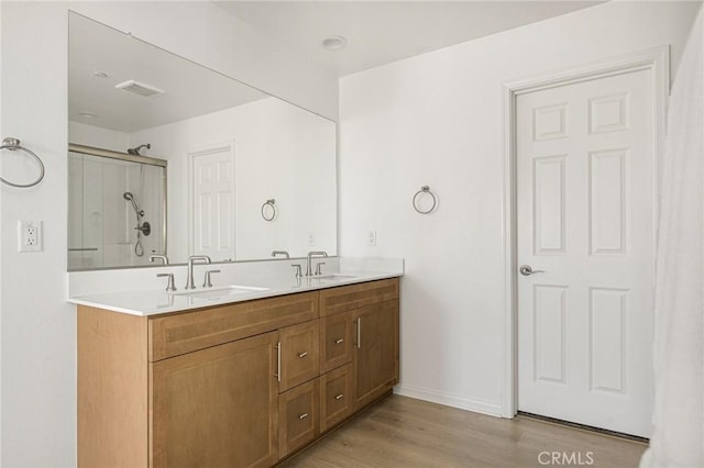 bathroom with vanity, wood-type flooring, and a shower with door