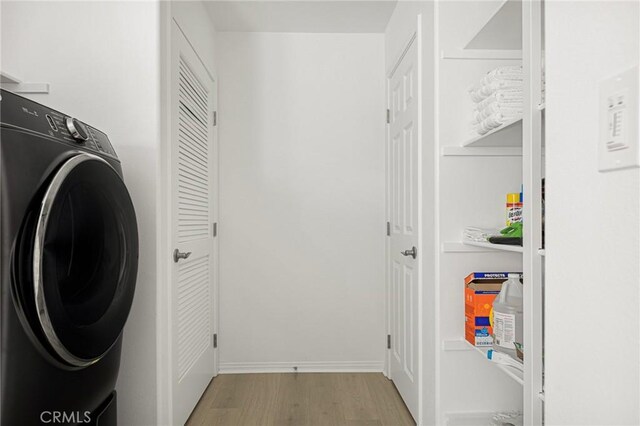 laundry room with washer / dryer and light hardwood / wood-style flooring