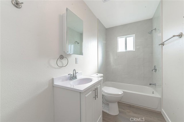 full bathroom with toilet, vanity, wood-type flooring, and tiled shower / bath