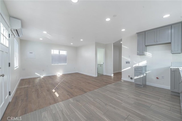 unfurnished living room with a wall mounted air conditioner