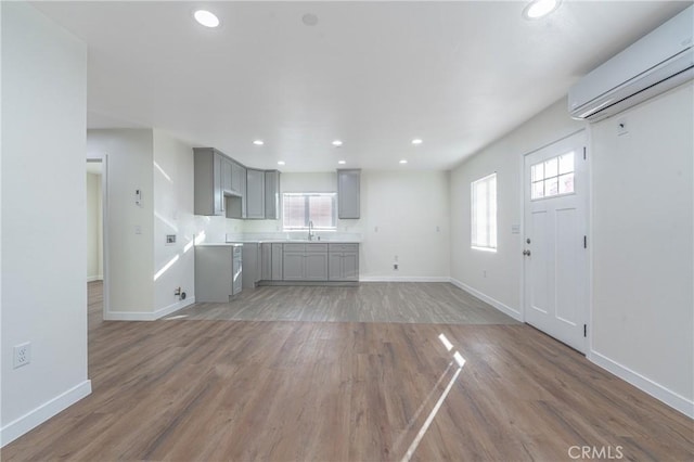 unfurnished living room featuring dark wood-type flooring and a wall mounted air conditioner