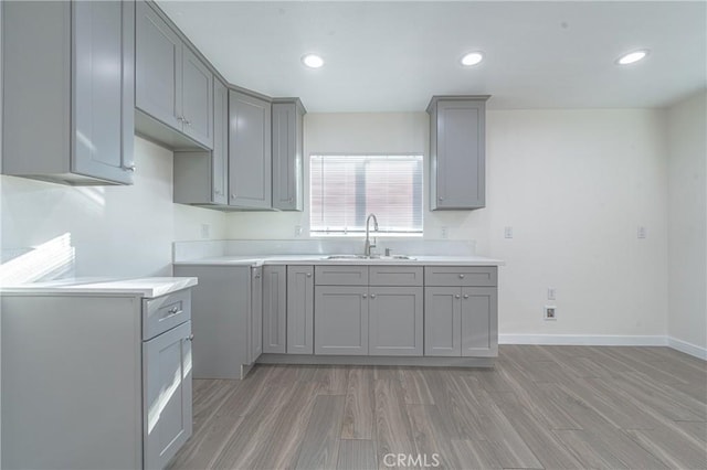 kitchen with hardwood / wood-style flooring, sink, and gray cabinets