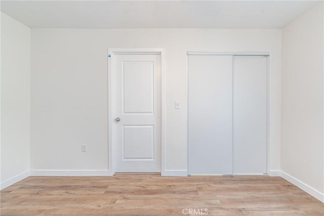 unfurnished bedroom featuring a closet and light hardwood / wood-style flooring