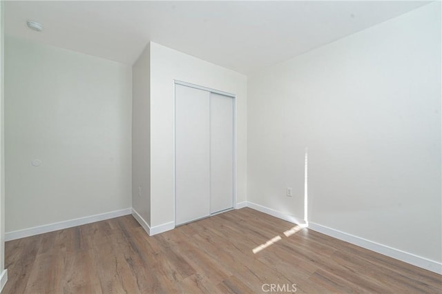 unfurnished bedroom featuring a closet and light hardwood / wood-style floors