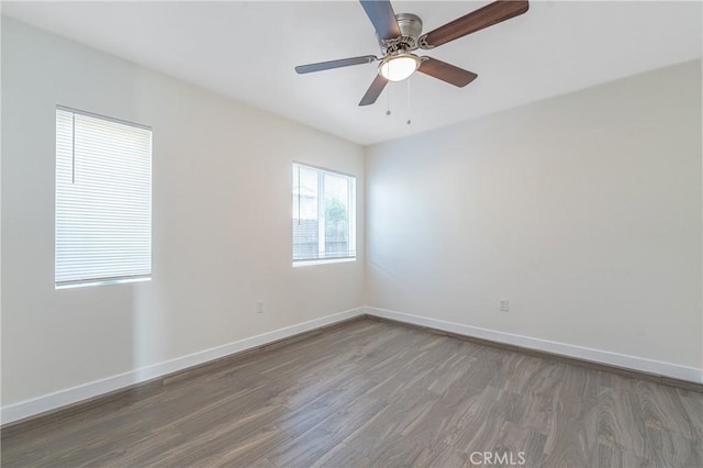 spare room with ceiling fan and dark hardwood / wood-style flooring