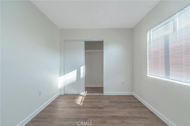 unfurnished bedroom featuring a closet and wood-type flooring