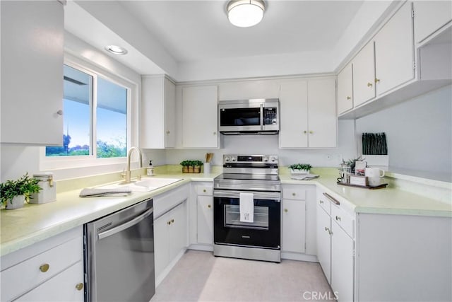 kitchen featuring sink, stainless steel appliances, and white cabinetry