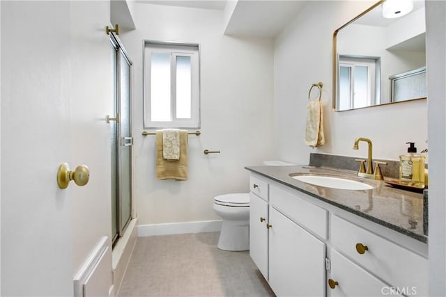 bathroom featuring a shower with door, tile patterned floors, toilet, and vanity