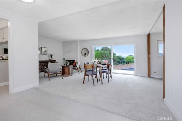 carpeted dining space featuring a brick fireplace