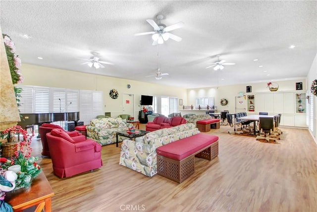 living room with a textured ceiling and light hardwood / wood-style floors