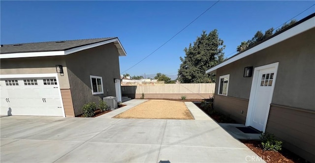 view of side of home featuring a garage and central air condition unit