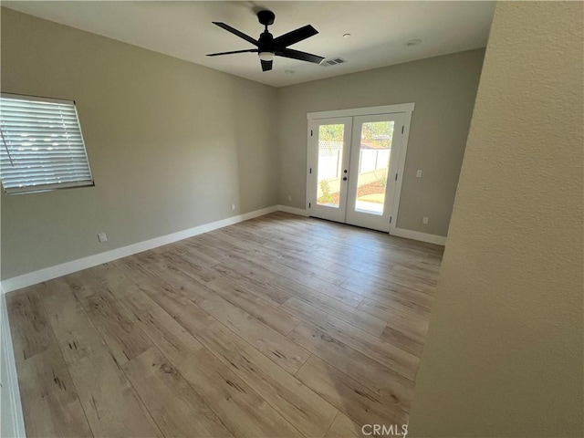 unfurnished room with ceiling fan, light hardwood / wood-style floors, and french doors