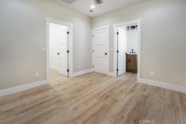 interior space with ensuite bath and light wood-type flooring