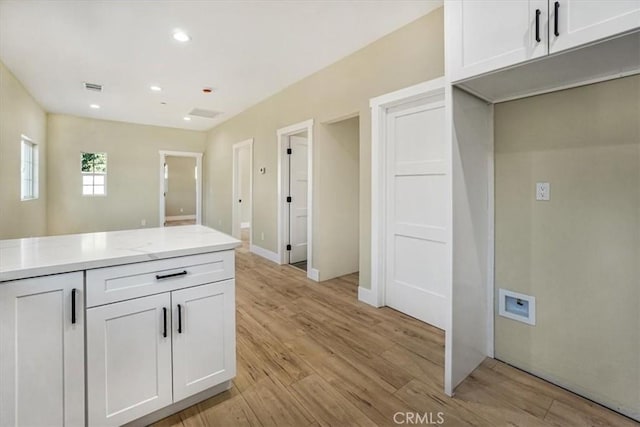 kitchen with white cabinets and light hardwood / wood-style flooring