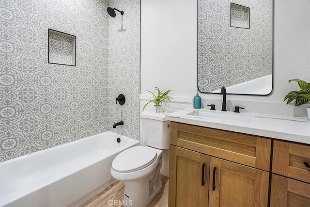 full bathroom featuring toilet, tiled shower / bath combo, vanity, and hardwood / wood-style flooring