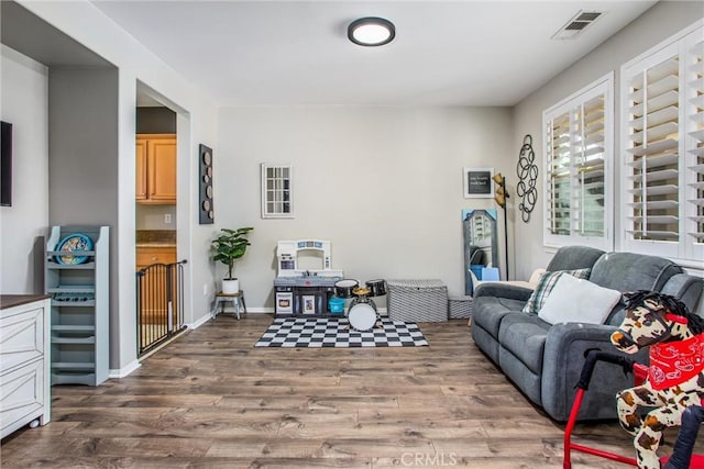 living area with visible vents and wood finished floors