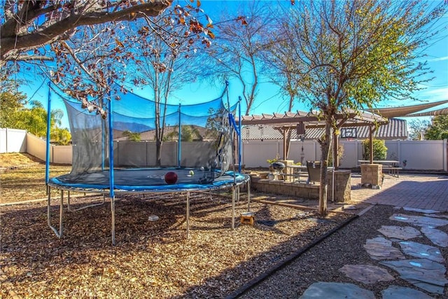 view of yard featuring a patio area, a pergola, and a trampoline