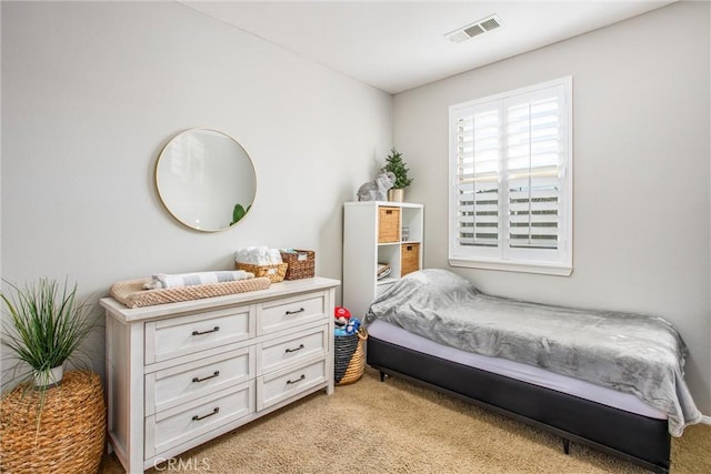 bedroom with visible vents and light carpet