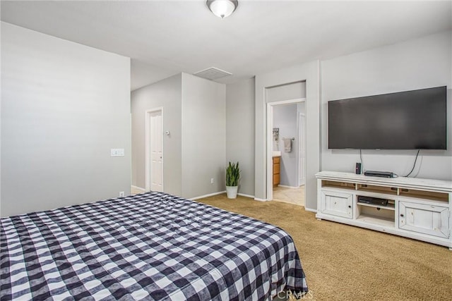 bedroom featuring light colored carpet and connected bathroom