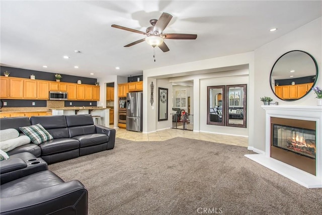 living area with ceiling fan, recessed lighting, light colored carpet, and baseboards