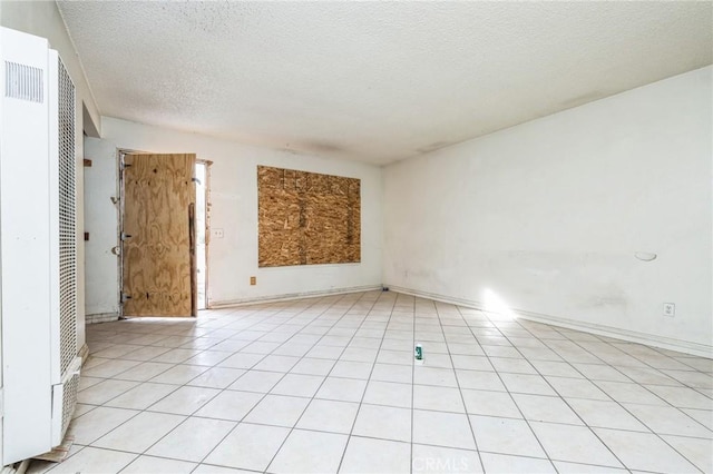 tiled spare room featuring a textured ceiling