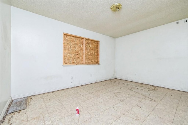 unfurnished room with a textured ceiling