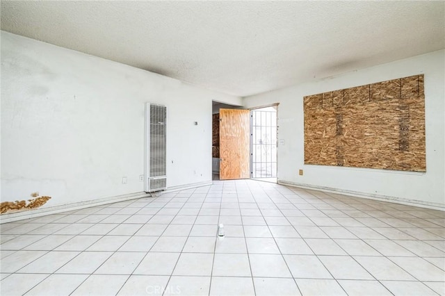 spare room featuring a textured ceiling and light tile patterned floors