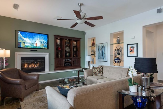 living room featuring ceiling fan and built in features