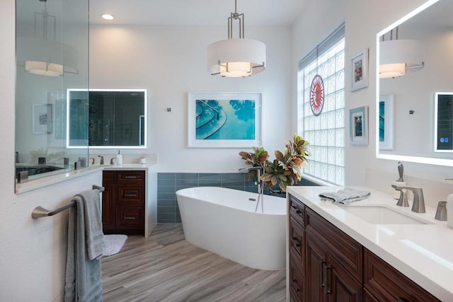 bathroom featuring hardwood / wood-style flooring, vanity, and independent shower and bath