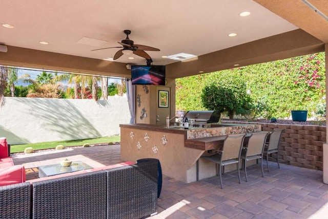 view of patio with ceiling fan, a grill, area for grilling, and an outdoor bar