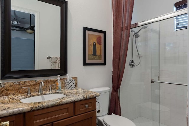 bathroom featuring toilet, vanity, and an enclosed shower