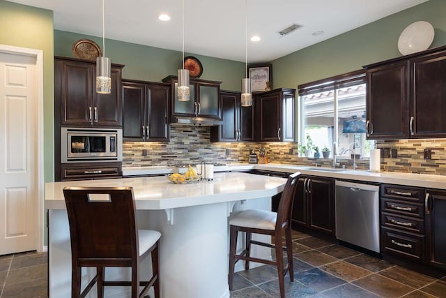 kitchen with tasteful backsplash, a center island, stainless steel appliances, and pendant lighting