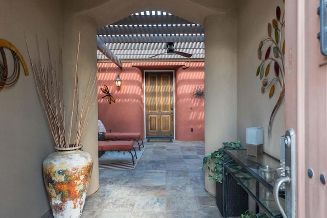 property entrance featuring ceiling fan, a patio, and a pergola