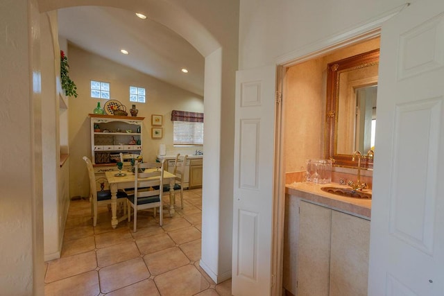 bathroom with lofted ceiling, tile patterned floors, and sink