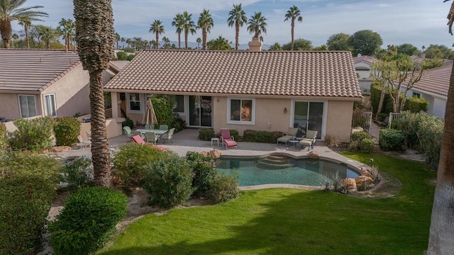 back of house featuring a patio area and a lawn