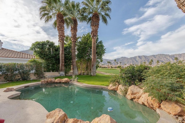 view of pool with a mountain view and a yard