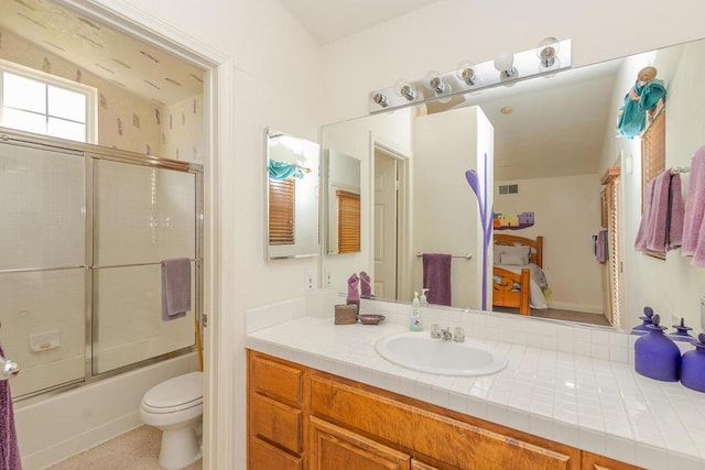 full bathroom with toilet, vanity, and combined bath / shower with glass door